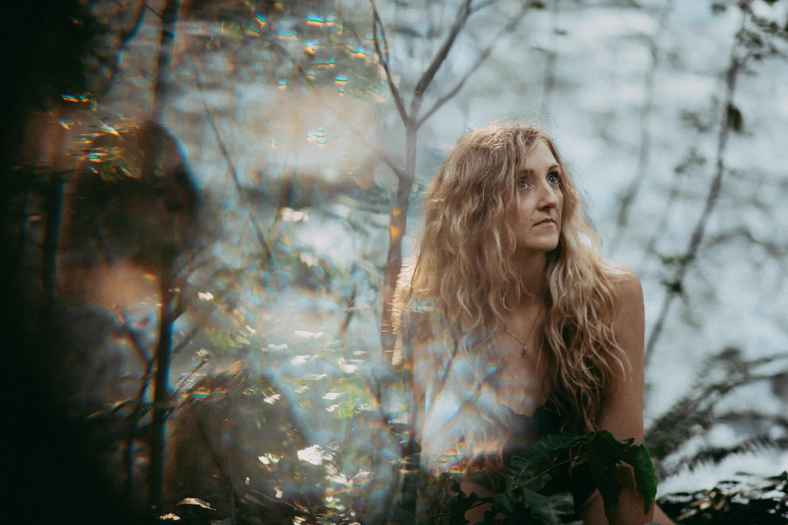 Samantha in quiet reflection amongst woodland light
