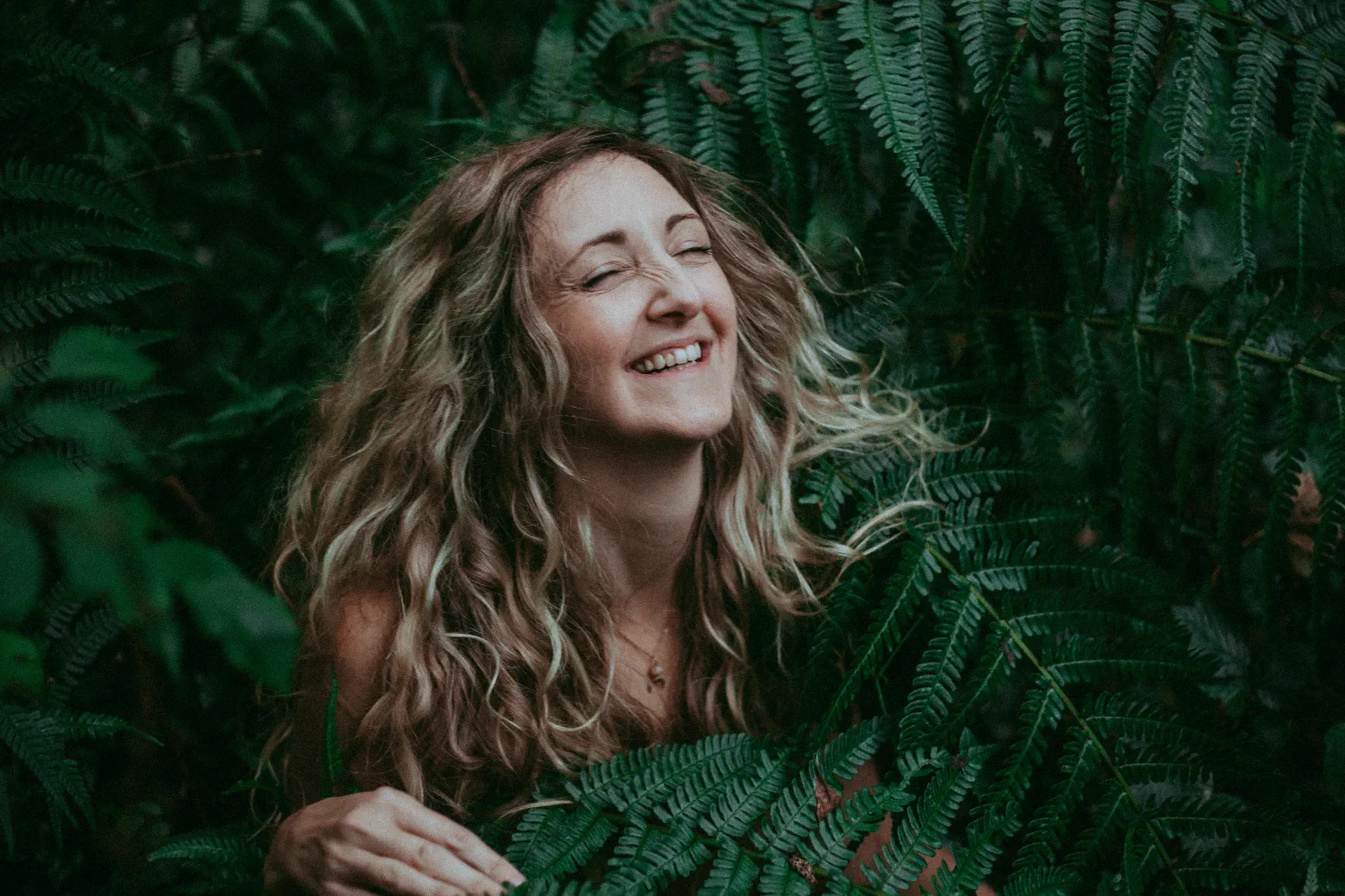 Samantha Bennett smiling amongst ferns
