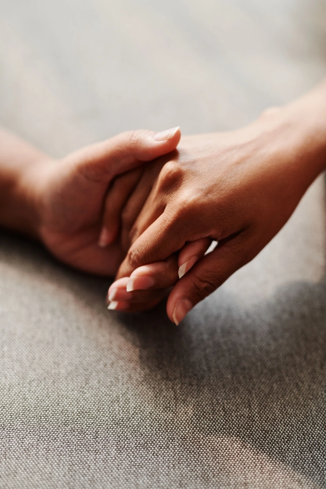 Two hands clasped together, representing the trust and support built through psychotherapy and mediation sessions in Cardiff and Swansea