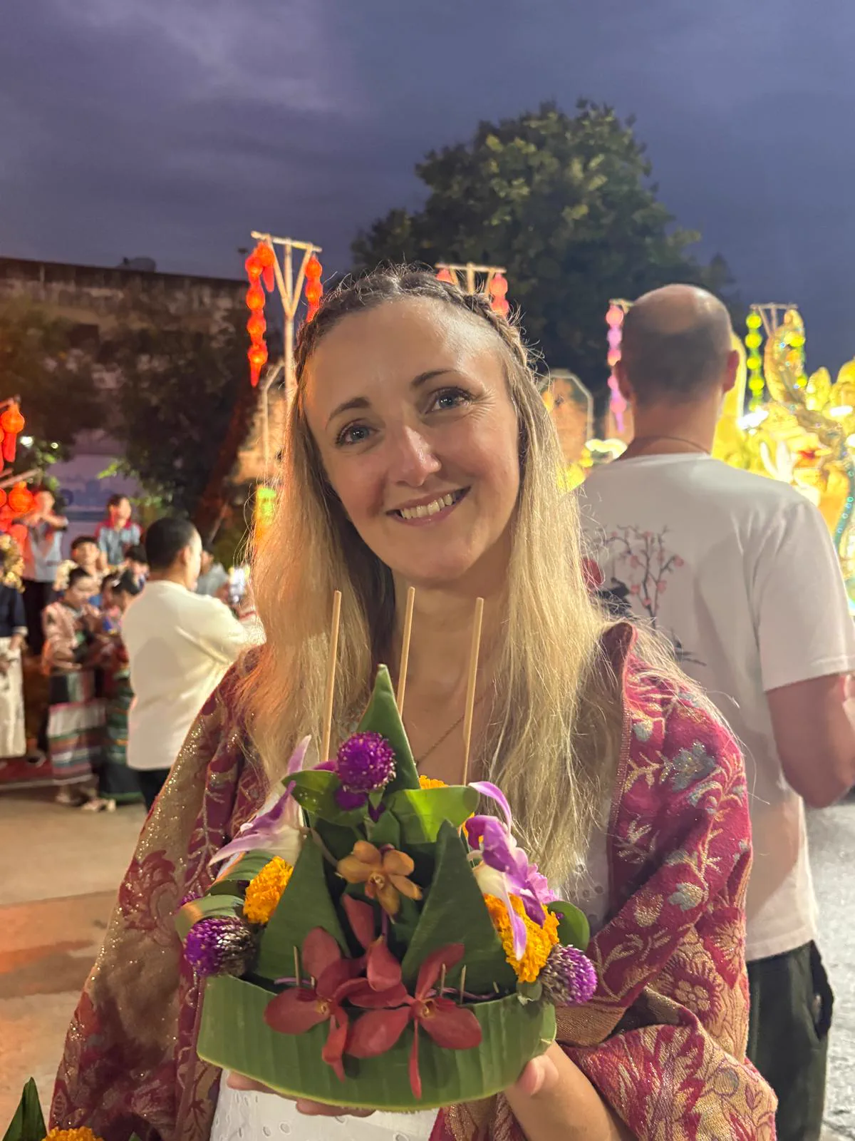 Samantha Bennett smiling warmly, holding a flower offering